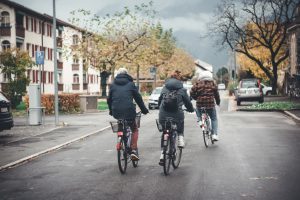 Three friends riding bikes on the street.