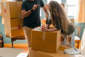 A man and a woman packing some boxes for moving